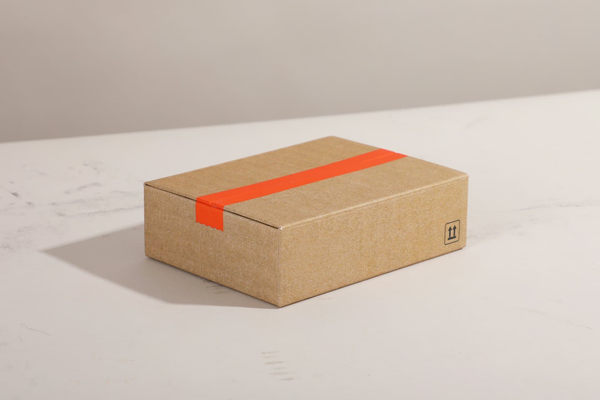 Caja de cartón sellada con cinta de embalaje de color naranja