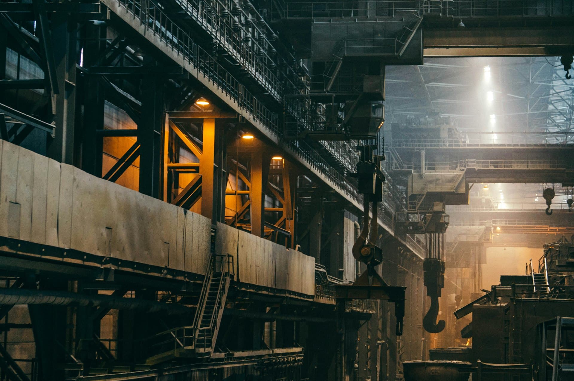 Interior de una planta industrial con estructuras metálicas y puentes grúa